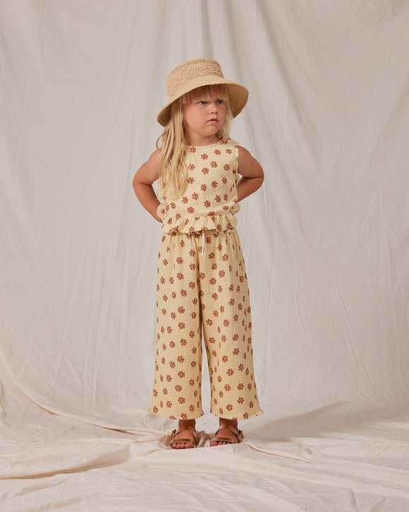 Rylee + Cru - A young child in a studio wearing a soft yellow two-piece set with daisies
